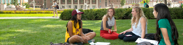 Group of four students studying outside in the Northrop Mall on East Bank 